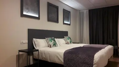 a bedroom with a bed with a mirror and towels at Hotel Malecon in O Barco de Valdeorras
