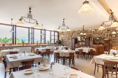 a restaurant with white tables and chairs and windows at Pazo de Esposende in Esposende