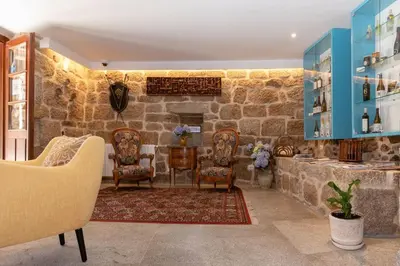 a room with chairs and a stone wall at Pazo de Esposende in Esposende
