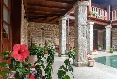 a patio with a red flower and a swimming pool at Pazo de Esposende in Esposende