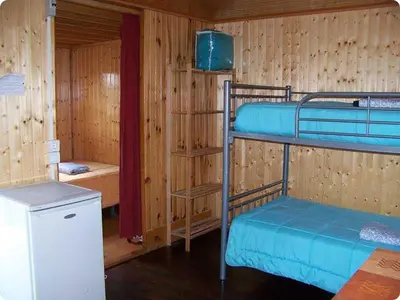 a room with two bunk beds and a refrigerator at Camping Fragadeume in Monfero