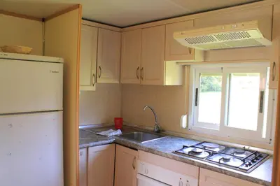 a kitchen with a sink and a white refrigerator at Camping Fragadeume in Monfero