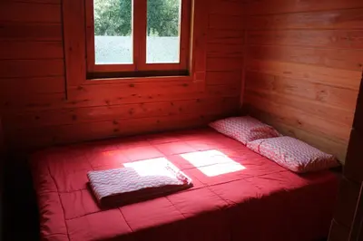 a red bed in a room with a window at Camping Fragadeume in Monfero