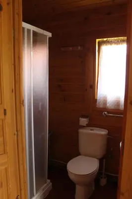 a bathroom with a toilet and a glass shower at Camping Fragadeume in Monfero