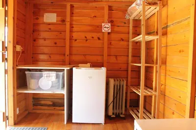 a small refrigerator in a room with wooden walls at Camping Fragadeume in Monfero