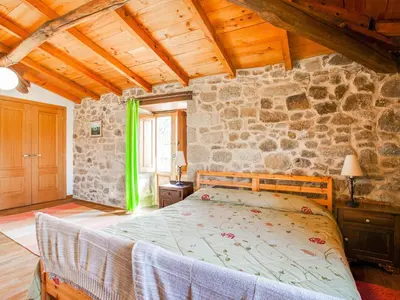 a bedroom with a bed and a stone wall at Holiday Home in Castrotañe near Sil Cañon in Castillón