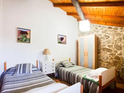 two beds in a room with a stone wall at Holiday Home in Castrotañe near Sil Cañon in Castillón