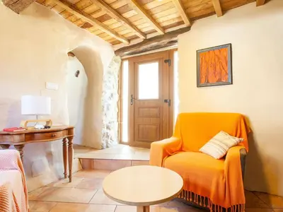 a living room with an orange chair and a table at Holiday Home in Castrotañe near Sil Cañon in Castillón
