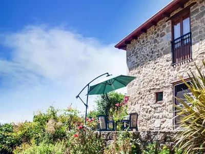 a green umbrella sitting on the side of a building at Holiday Home in Castrotañe near Sil Cañon in Castillón