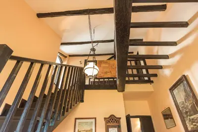 a hallway with wooden beams and a chandelier at Casona Las Burillas in Villar de los Barrios
