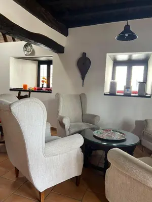 a living room with two chairs and a table at Casona Las Burillas in Villar de los Barrios
