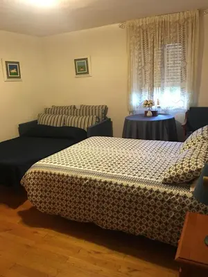 a bedroom with two beds and a table and a window at Casa Sanabresa in Galende