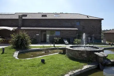 a house with a fountain in front of a yard at Albergue Turistico Salceda in Salceda