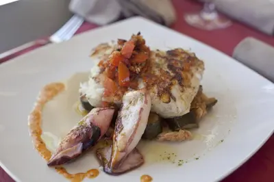 a plate of food with meat and vegetables on a table at Albergue Turistico Salceda in Salceda