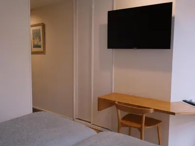 a bedroom with a desk and a television on a wall at Hotel Zarampallo in Ourense