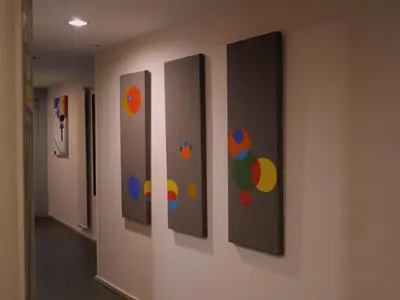 a row of paintings on a wall in a hallway at Hotel Zarampallo in Ourense