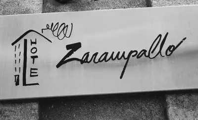 a sign on the side of a brick wall at Hotel Zarampallo in Ourense