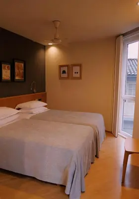 a bedroom with two beds and a window at Hotel Zarampallo in Ourense