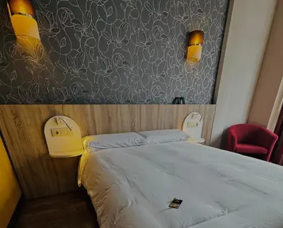 a bedroom with a bed and a red chair at Hotel Gran Casona de Sanabria in Puebla de Sanabria