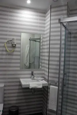 a bathroom with a sink and a mirror at Hotel Altiana in Ourense