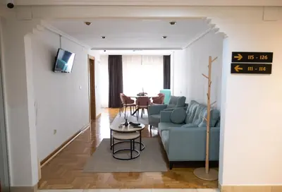 a living room with a blue couch and a table at Hotel El Molinón in Cangas del Narcea