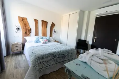 a bedroom with two beds and a wooden headboard at Hotel rural Finca Vivaldi Nature & Spa in San Miguel de las Dueñas