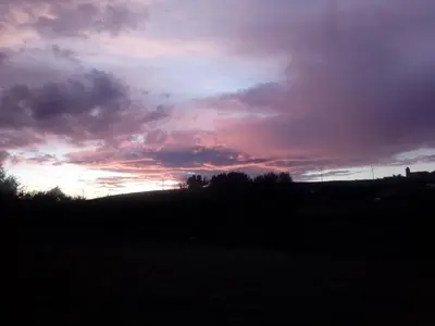 a sunset on a hill with a field and trees at Casa Rosi. Cumbres borrascosas Brañuelas in Villagatón