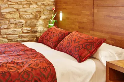 a bed with two red pillows on top of it at Mapoula PR Boutique in Santiago de Compostela