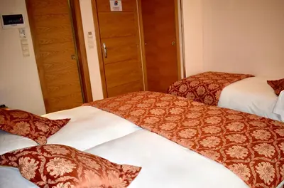 a hotel room with two beds with red and white blankets at Mapoula PR Boutique in Santiago de Compostela