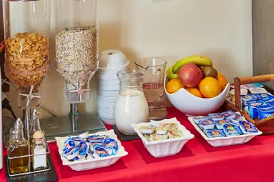 a table with a red table cloth with snacks and milk at Mapoula PR Boutique in Santiago de Compostela