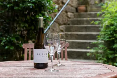 a bottle of wine and two wine glasses on a table at Casa dos Ulloa in Esposende