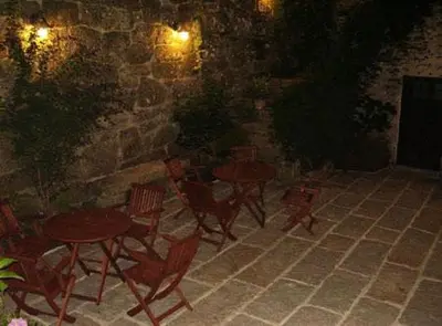 a patio with tables and chairs and a stone wall at Casa dos Ulloa in Esposende