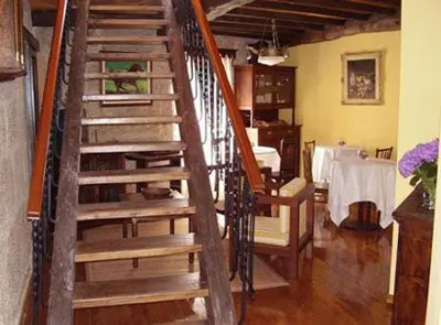 a wooden staircase in a room with a table at Casa dos Ulloa in Esposende