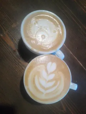 two cups of coffee sitting on a wooden table at La Rosa del Agua in El Acebo de San Miguel