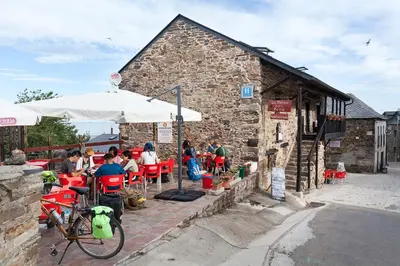 a group of people sitting at a table outside a building at La Rosa del Agua in El Acebo de San Miguel