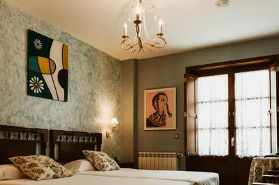 a bedroom with two beds and a chandelier at Casa da Capilla in Gres
