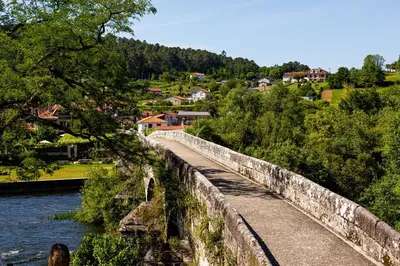 a woman standing on a stone wall next to a river at Casa da Capilla in Gres