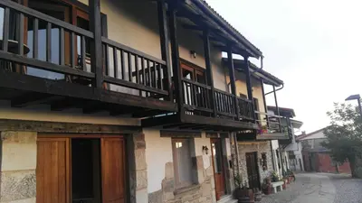 a building with a wooden door and a balcony at Falagueira in Monforte de Lemos