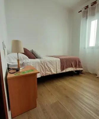 a bedroom with a bed and a table with a lamp at Pensión Río Umia in Caldas de Reis