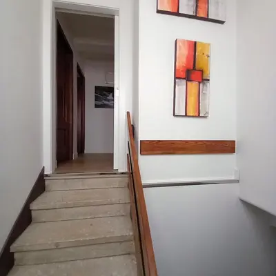 a hallway with two paintings on the wall and a staircase at Pensión Río Umia in Caldas de Reis