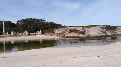 a beach next to a body of water at San Ciprian, belleza y tranquilidad. in San Ciprián