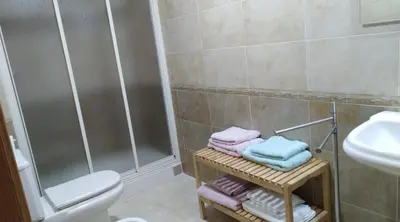 a bathroom with a shower and a sink and towels at San Ciprian, belleza y tranquilidad. in San Ciprián