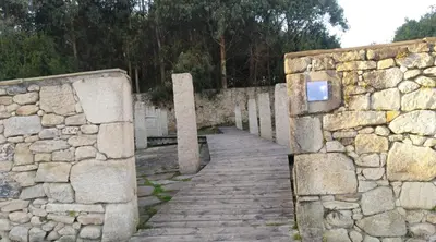 a stone wall and a wooden walkway next to a stone fence at San Cibrao,belleza y tranquilidad. in San Ciprián