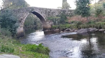 an old stone bridge over a river at San Cibrao,belleza y tranquilidad. in San Ciprián