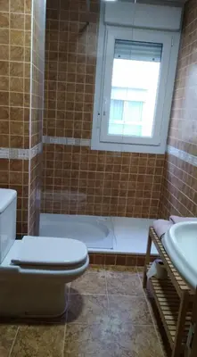 a bathroom with a toilet and a tub and a window at San Cibrao,belleza y tranquilidad. in San Ciprián