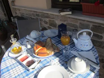 a table with a plate of food and orange juice at La Posada de Toribia in Val de San Lorenzo