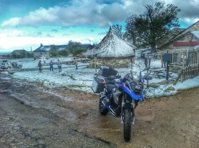 a blue motorcycle parked on the side of the road at La Posada de Toribia in Val de San Lorenzo