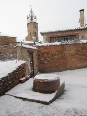 a brick building with snow on the ground at La Posada de Toribia in Val de San Lorenzo