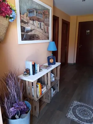 a room with a book shelf with books and a lamp at La Posada de Toribia in Val de San Lorenzo