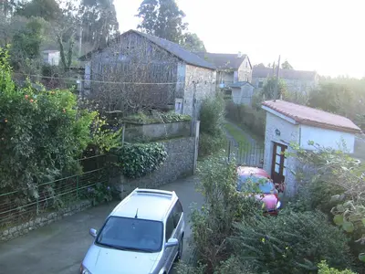 a white car parked in front of a house at Casa Xan da Pena in Villarmayor